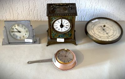 trois horloges et une horloge posée sur une table, les unes à côté des autres