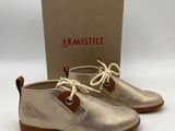 a pair of metallic shoes with a box in the background