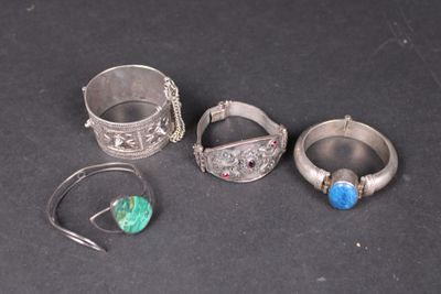 trois bagues en argent et une bague ornée d'une pierre bleue sur un fond noir