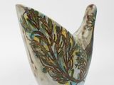 a ceramic bird that is sitting on a white surface