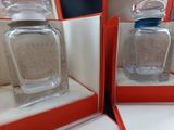two empty glass bottles in a red box on a white surface