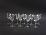 six empty wine glasses lined up in a row on a black surface