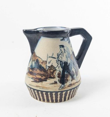 a blue and white pitcher with a painting of a man on a horse