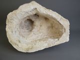 a white rock with a hole in it on a gray surface