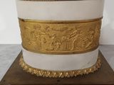 a white and gold box on a wooden base