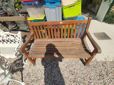 a shadow of a person sitting on a wooden bench