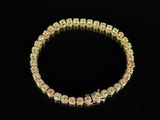 a gold bracelet with cubic beads and a diamond clasp