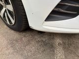 a close up of a white car ' s front bumper