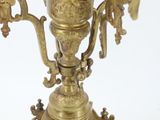 a gold vase on a stand on a white surface