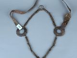 un vieux collier auquel est suspendue une clé, autour de son cou