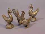 three brass figurines of birds on a table