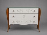 a white chest of drawers with a glass top and wooden legs