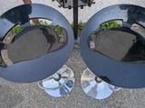 two black chairs sitting next to each other on a sidewalk