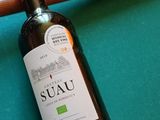 une bouteille de vin posée sur une table de billard, à côté d'une queue de billard