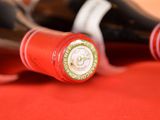 several bottles of red wine are lined up on a red table