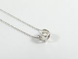 gros plan d'un collier en argent sur une surface blanche