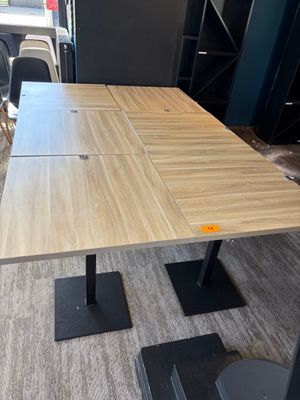 une table en bois avec quatre chaises noires dans une pièce