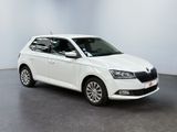 the white skoda is parked in a large white room