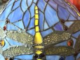 a close up of a stained glass lamp with dragonflies on it