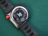 a close up of a watch on a green surface
