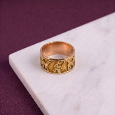 une photo d'une bague en or posée sur une surface en marbre