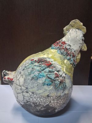a ceramic sculpture of a chicken on display on a table