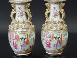une paire de vases chinois posés sur une surface noire, sur fond noir