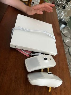 une personne assise à une table, avec une souris d'ordinateur et une bouteille d'alcool