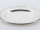 a silver plate on a white table with a white background