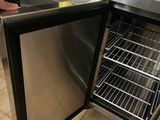 a person standing in front of a stainless steel refrigerator