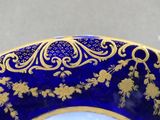 a blue and gold plate with gold flowers on it