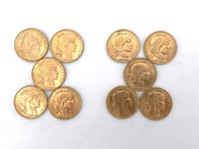 several different types of gold coins on a white surface