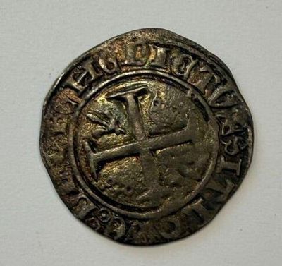a close up of a coin with a cross on it