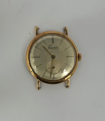 a gold watch on a white surface with a white background