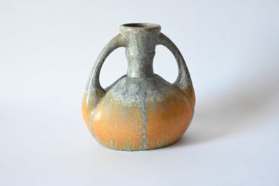 a small vase that is sitting on a white surface