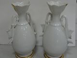 two white vases that are sitting on a table