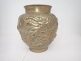 un vase doré orné d'un dragon sur un fond blanc