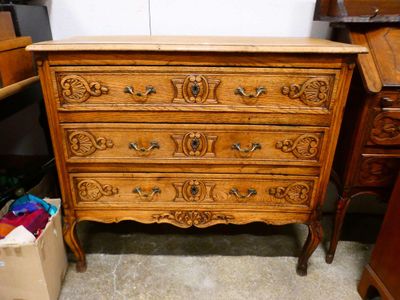 une commode en bois avec des tiroirs et un miroir posé dessus