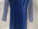 a blue dress hanging on a hanger on a white wall
