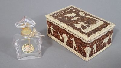 un petit flacon de parfum posé à côté d'une petite boîte