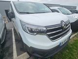 La camionnette blanche est garée à côté d'autres voitures sur le parking.