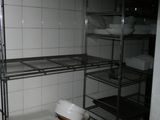a metal shelf with dishes on it in a kitchen