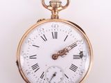 une montre de poche en or avec des chiffres romains sur le cadran