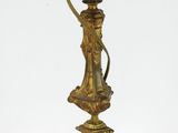 une lampe ancienne en laiton surmontée d'une tête de lion