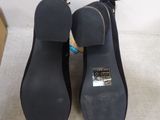 pair of women ' s black shoes on a white surface with a box in the background