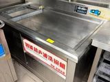 une grande cuisine professionnelle équipée d'un plan de travail en acier inoxydable