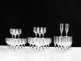 several empty wine glasses are lined up on a white table