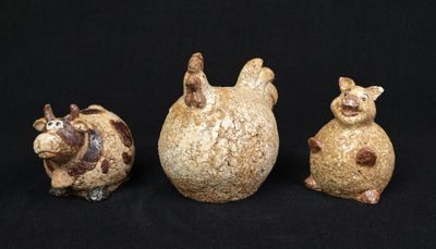 three figurines of animals sitting on a black surface