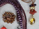 many different necklaces and bracelets laid out on a table