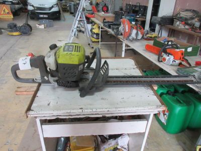 une tronçonneuse posée sur un établi dans un garage